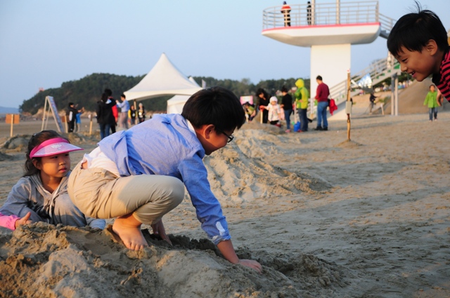 지난 주말 춘장대에서 열린 제1회 모래 조각 축제에서 아이들이 모래 조각을 만들며 즐거워하고 있다